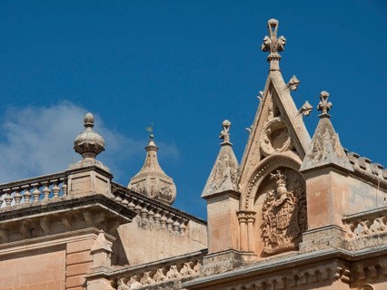 Gothic ecclesiastical architecture with ornate elements and towers under a blue sky, the town of