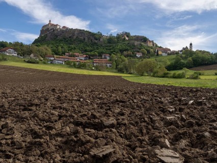 Clods of earth in farmland, Riegersburg Castle in the background, near Riegersburg, Styria,