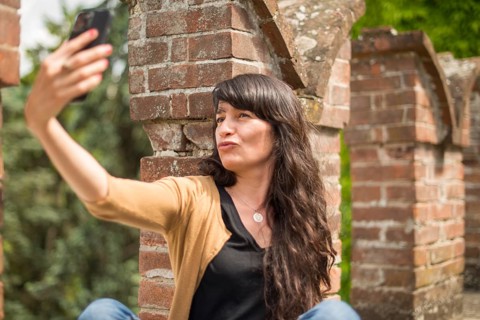 Young hispanic woman in casual clothing focused on conversation with smartphone in a peaceful