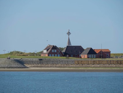Quiet coastal scene with houses on the shore under a clear sky, Baltrum Germany