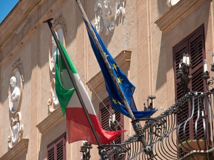 A building with an Italian and European flag, restrained historical architecture, palermo in sicily