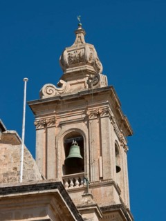 Detailed view of a baroque bell tower with decoration and blue sky in the background, Historic
