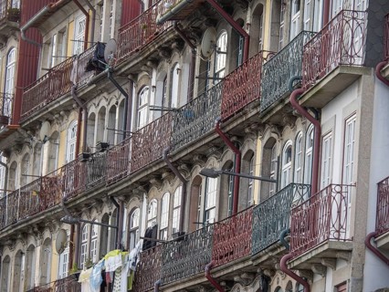 Facades of multi-storey buildings with classic balconies and metal railings, old houses in the