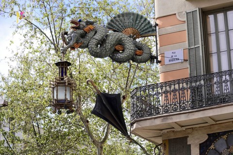Barcelona, Catalonia, Spain, Europe, Dragon statue carrying a decorative lantern and an umbrella in