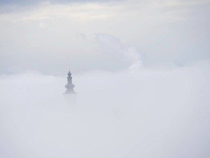Church tower rises out of the morning mist, Frauenberg pilgrimage church, near Leibnitz, Styria,