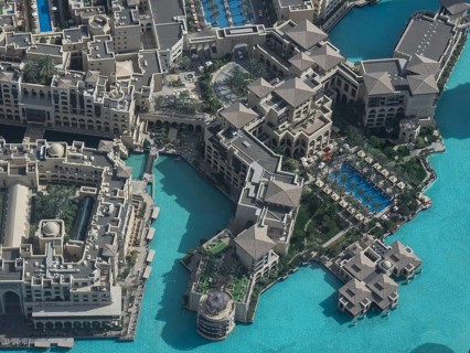 Aerial view of a large building complex with several swimming pools and turquoise-coloured water in