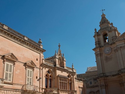 Historic buildings and a bell tower under a clear blue sky, the town of mdina on the island of