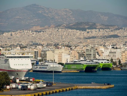 View of a harbour with several ships in front of a city and mountains, Ancient buildings with