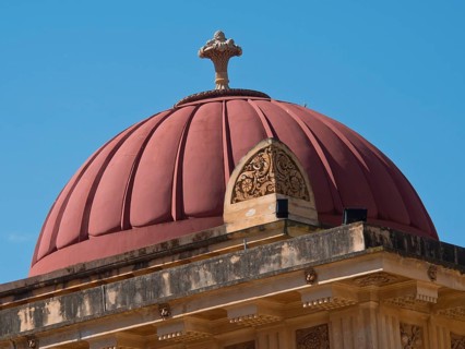 A red dome on a historic building under a clear blue sky, palermo in sicily with an impressive