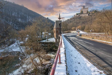 Beautiful landscape in winter with ice and snow. Waterfall of the river Elz near the castle
