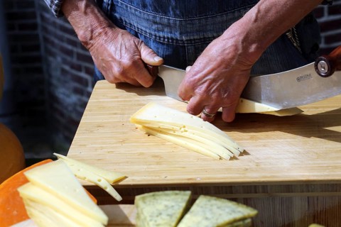 A man cuts chees at the cheese market in Alkmaar., Alkmaar, Netherlands