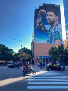 Street scene with giant mural showing Lionel Messi in winning pose, Buenos Aires, Argentina, South