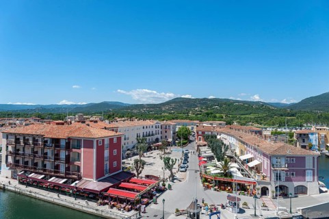 Market square with shops and restaurants, in the background the hills of the Massif des Maures,