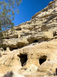 View upwards to sandstone rocks at the edge of Matala bay with entrances to caves of former Roman