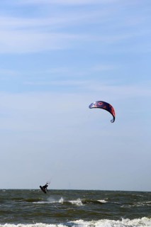 A kite surfer enjoys the waves on a glorious day along the Dutch coast. Castricum, Netherlands