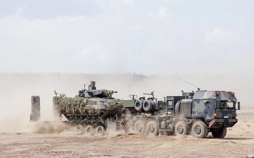 A Cougar infantry fighting vehicle is unloaded from a Mammut heavy goods transporter during the
