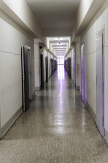 Narrow corridor with neon lights and open doors leads into the distance, Berlin-Hohenschoenhausen