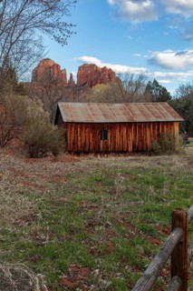 Cathedral Rock sandstone formations tower over a rustic barn at the Crescent Moon Picnic Site in