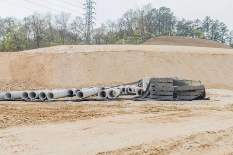 Concrete culvert pipes at base of dirt hillside at rural construction site in Daejeon, South Korea,