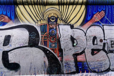 Mural showing an angel with wings, overlaid with graffiti and scribbles on an urban wall, mural,