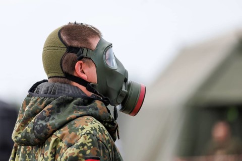 German soldiers from an NBC defence unit in protective clothing practise decontamination during the