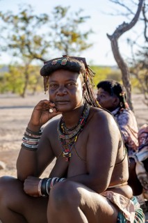 Hakaona woman with traditional kapapo hairstyle and colourful necklaces, portrait, in the morning