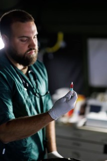 A soldier from the Bundeswehr medical service holds a simulated blood sample during an exercise.
