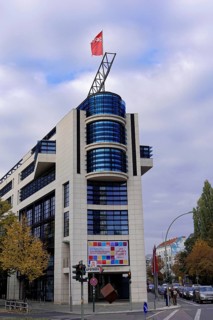 A modern office building on a street corner with a flag and autumnal trees, Willy-Brandt-Haus, SPD