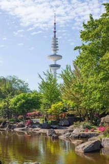 Japanese garden in the Planten un Blomen park with Hamburg television tower and park pond in