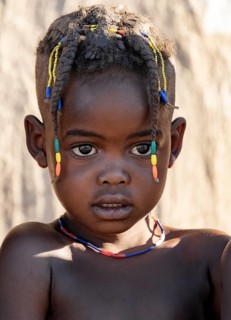 Hakaona child with traditional hairstyle, portrait, in the morning light, Angolan tribe of the