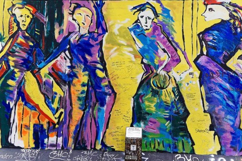 Colourful graffiti showing several dynamic dancers in a moving style, mural, East Side Gallery,