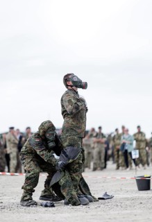 German soldiers from an NBC defence unit in protective clothing practise decontamination during the