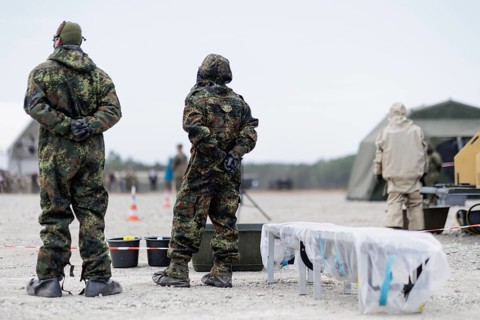 German soldiers from an NBC defence unit in protective clothing practise decontamination during the