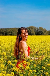 Woman stands in a rape field and laughs at you