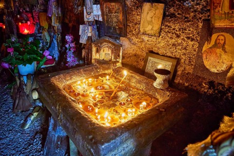 Rock Chapel, Archangel Michael Panormitits, Illuminated altar with burning candles in a cave,