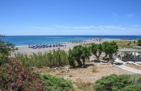Beach of Frangokastello with sunshades sunbeds on the right at the edge of the picture Tavern Cafe