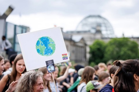 Demonstrators with signs at Fridays for Future in front of the Reichstag building, taken during the