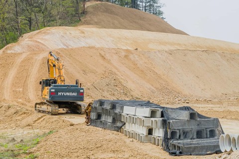 Hyundai backhoe parked at base of dirt hillside at construction site in Daejeon, South Korea, Asia