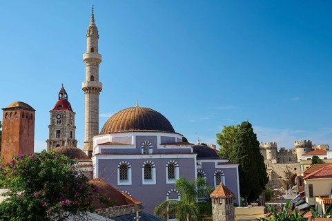Suleiman Mosque, Historic building with minaret and domes, red roofs and fortress under blue sky,
