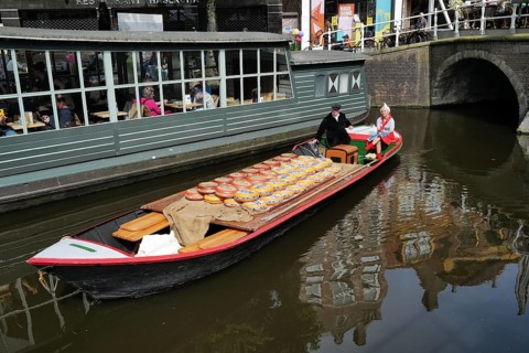 A load of Beemster cheese being transported on a canal in the city centre on market day. Alkmaar,