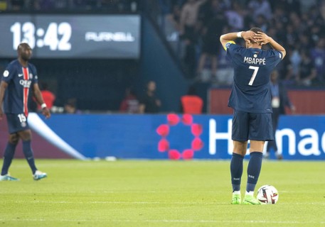Football match, captain Kylian MBAPPE' looking from behind and holding the ball at the top of his