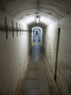 Well-lit narrow tunnel with concrete walls and electrical cables on the side, Heligoland, Germany,