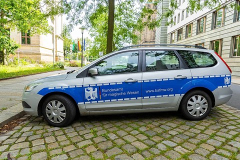 A car similar to a police car advertising a bookshop is parked in the government district of
