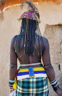 Hakaona woman with traditional kapapo hairstyle and hair ornaments with ostrich feathers, and