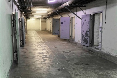 Long corridor in a prison with open metal doors and dirty walls. Cold and deserted,