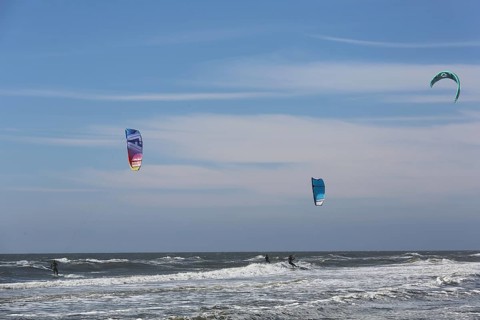 Kite surfers enjoy the waves on a glorious day along the Dutch coast. Castricum, Netherlands