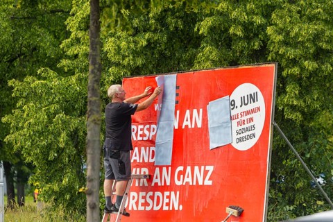 A poster artist renews a large SPD campaign poster for the elections on 8 June 2024, in the city