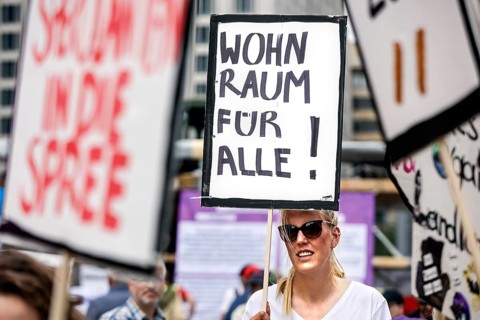 Woman holding a poster with the inscription Wohnraum fuer alle! Demo under the motto The rent is
