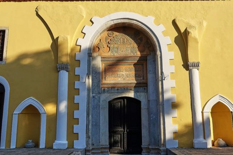 Ottoman Library, Yellow building with a large arch above the entrance door, richly decorated with