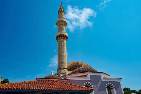 Suleiman Mosque, minaret and dome under blue sky with few clouds, red roofs and historical